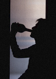 Man in silhouette behind frosted glass door drinking from spirits bottle